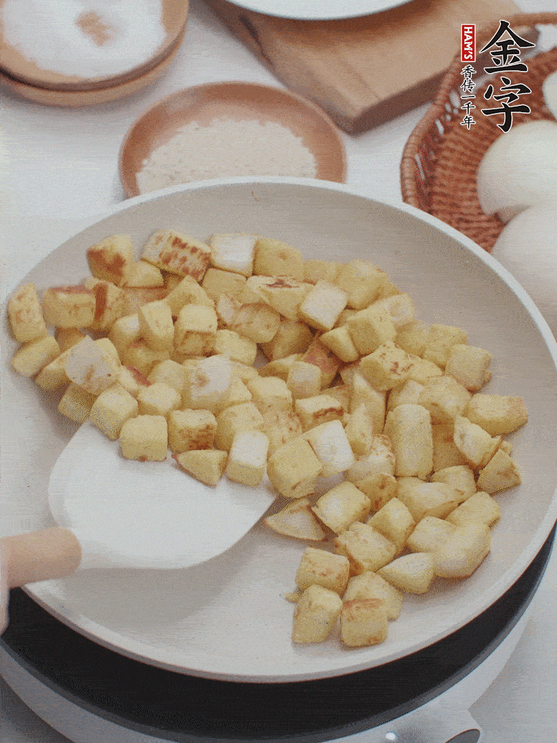 起鍋熱油，倒入饅頭丁，小火煎至蛋液凝固定型再翻面，饅頭丁部煎至金黃時盛起待用。