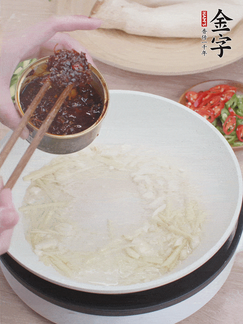 起鍋熱油，姜蒜、金字火腿干貝醬煸香。