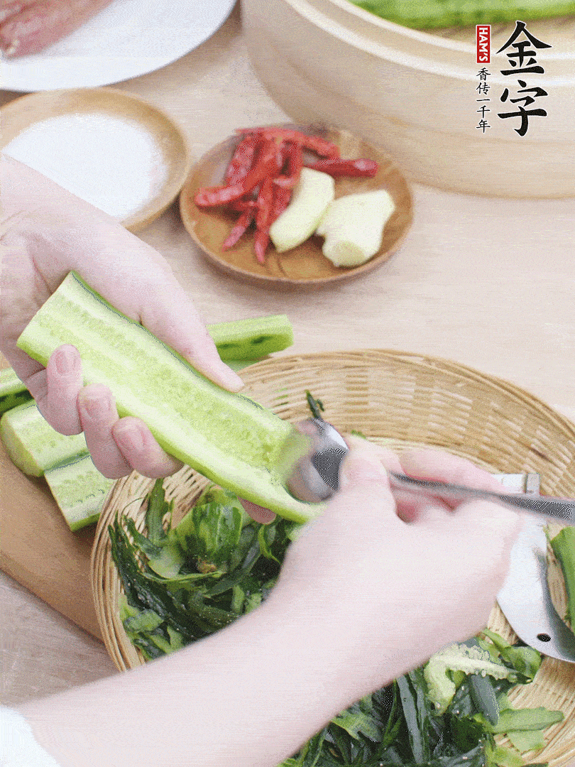 黃瓜削皮，對(duì)半切開，勺子挖去內(nèi)瓤，斜刀切片。青蒜斜刀切段。