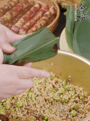 粽葉往下折，完全蓋住，兩側(cè)捏緊。