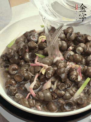 倒處理干凈的螺螄翻炒，加3勺料酒。加清水蓋過螺螄，中火蓋蓋煮5分鐘。