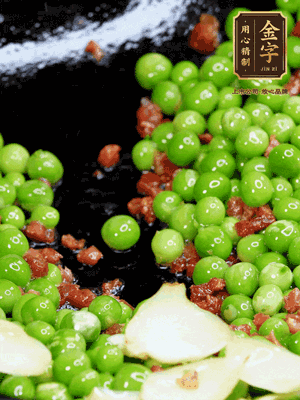 鍋內(nèi)少許油，下火腿煸香，再下甜豆米、百合翻炒，少許鹽、一點水煮到收干