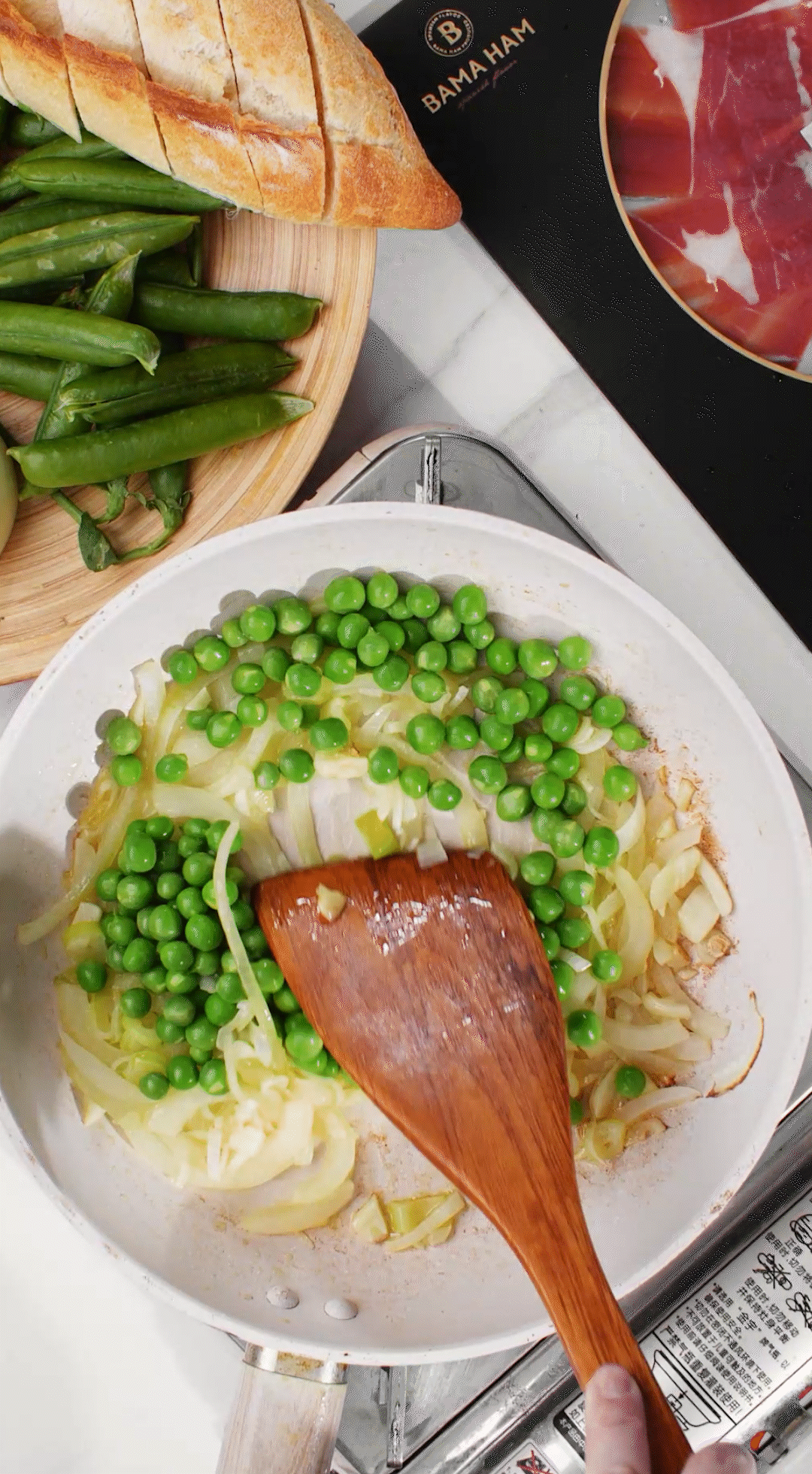 鍋中放入黃油融化，加入洋蔥絲、大蔥蔥白絲、蒜末翻炒變軟出香味。加入剛剛汆燙冰鎮(zhèn)后的豌豆，取出一點(diǎn)點(diǎn)待會(huì)擺盤裝飾用。加一點(diǎn)鹽 (和黑胡椒) 調(diào)味。