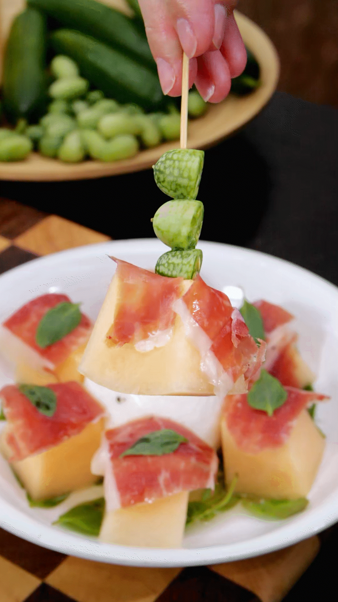 依次放上：布拉塔奶酪球、密瓜和巴瑪火腿